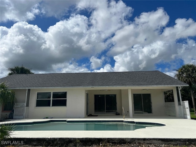 2875 18th Ave SE, Naples, FL 34117 - rear view of property featuring a patio, an outdoor pool, roof with shingles, and stucco siding
