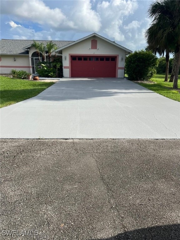 2875 18th Ave SE, Naples, FL 34117 - view of front of house with a garage, stucco siding, driveway, and a front yard