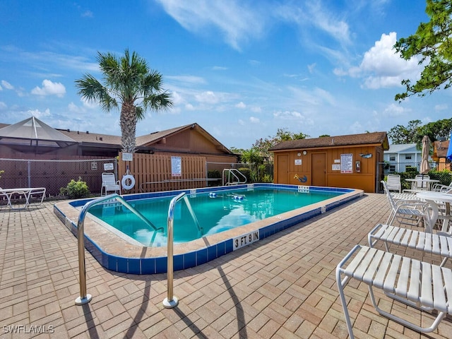 community pool with a patio and fence
