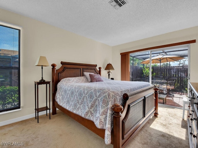 bedroom with access to exterior, visible vents, light carpet, baseboards, and a textured ceiling