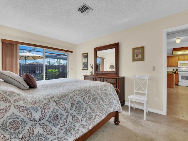bedroom with a textured ceiling, visible vents, access to exterior, baseboards, and light carpet