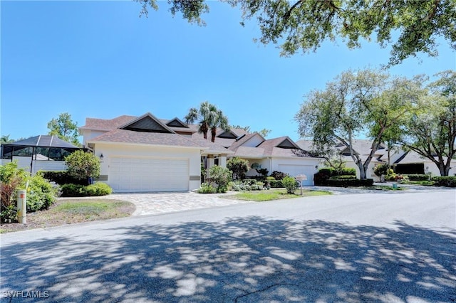 view of front of house featuring an attached garage, decorative driveway, and stucco siding