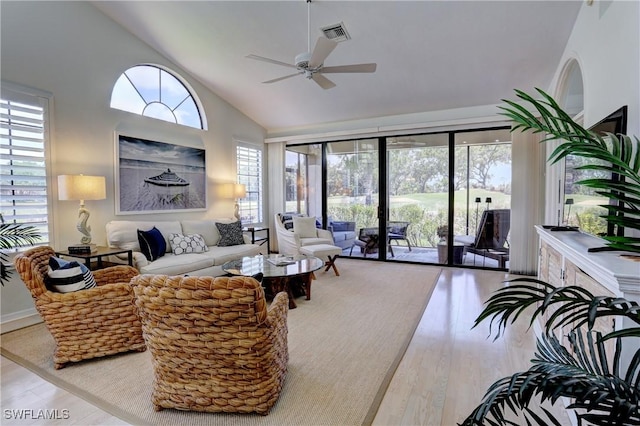 living room with high vaulted ceiling, a ceiling fan, wood finished floors, and visible vents