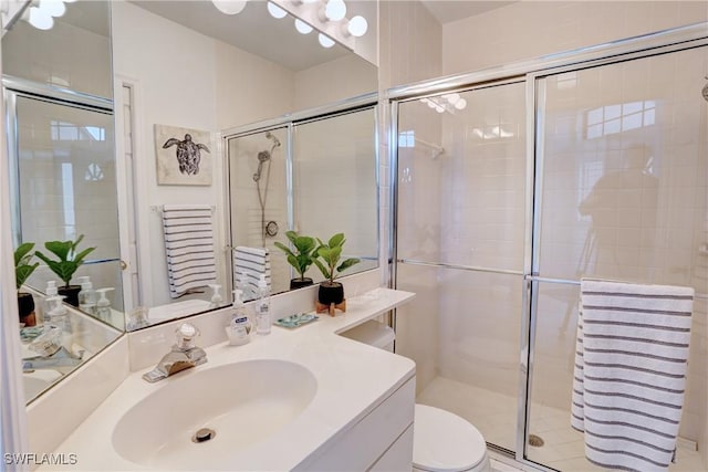 full bathroom featuring vanity, toilet, and a stall shower