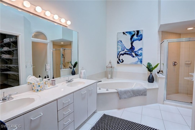 bathroom with double vanity, a sink, a bath, and a shower stall