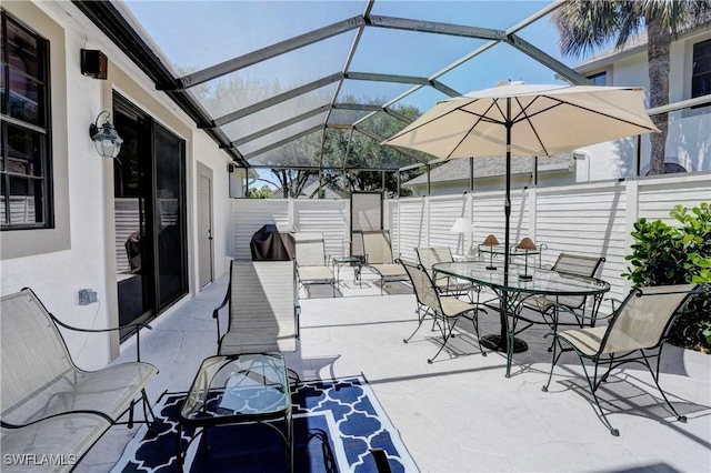 view of patio / terrace with glass enclosure, fence, and outdoor dining space