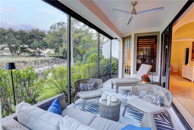 sunroom featuring ceiling fan and an outdoor living space