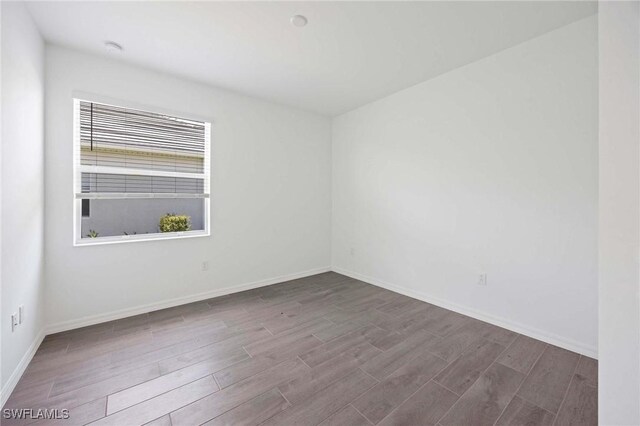 unfurnished room with baseboards and wood finished floors