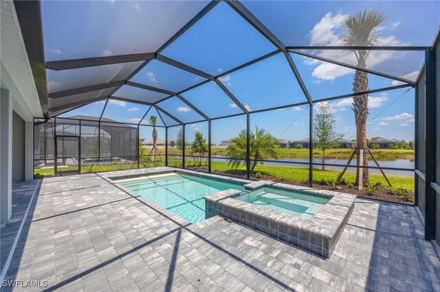 view of pool with a lanai, a water view, a pool with connected hot tub, and a patio area