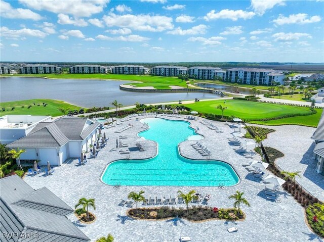 pool with a patio, a water view, and golf course view