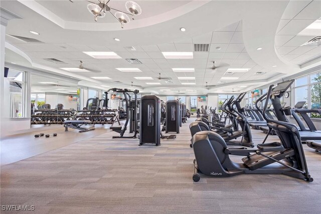 exercise room with carpet flooring, a notable chandelier, and visible vents