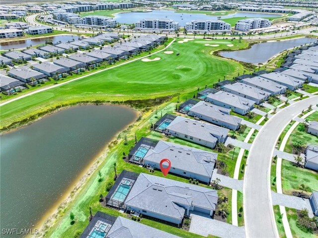drone / aerial view with a water view, view of golf course, and a residential view