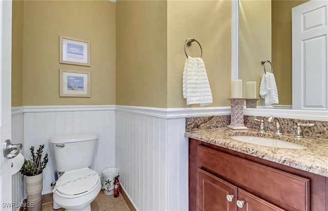 3402 Tigris Ln, Naples, FL 34119 - bathroom featuring tile patterned floors, vanity, toilet, and a wainscoted wall