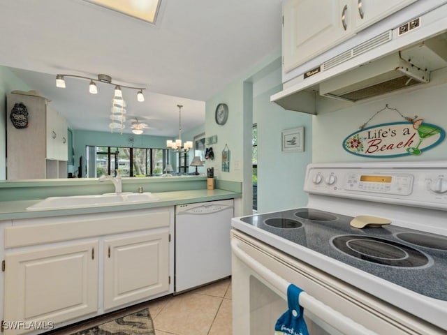 kitchen featuring a sink, light tile patterned floors, under cabinet range hood, white appliances, and white cabinetry