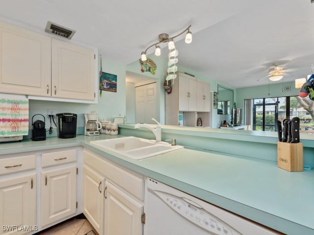 kitchen with a sink, dishwasher, light countertops, white cabinetry, and visible vents