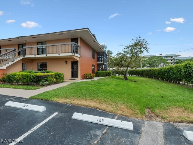 27 Greenbrier St Unit 6-109, Marco Island, FL 34145 - exterior space featuring a lawn, uncovered parking, and stucco siding