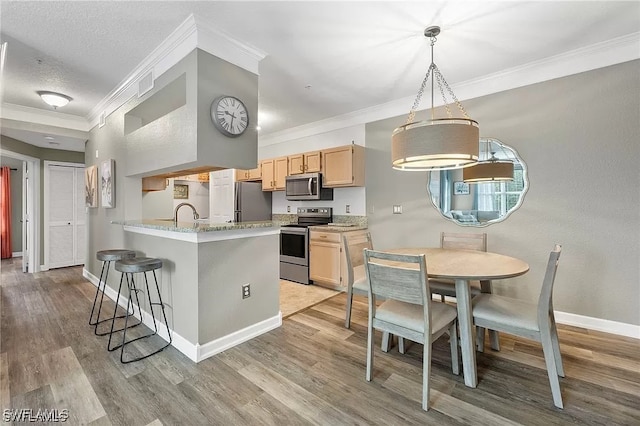11541 Villa Grand Unit 817, Fort Myers, FL 33913 - kitchen featuring crown molding, visible vents, light wood-style floors, a breakfast bar area, and appliances with stainless steel finishes
