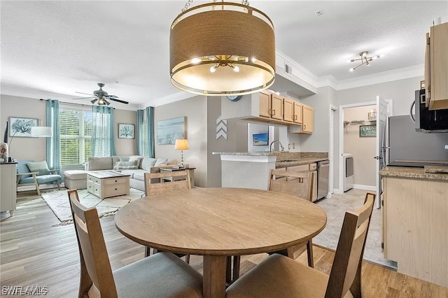 11541 Villa Grand Unit 817, Fort Myers, FL 33913 - dining room with ceiling fan, a textured ceiling, crown molding, light wood finished floors, and washer / dryer