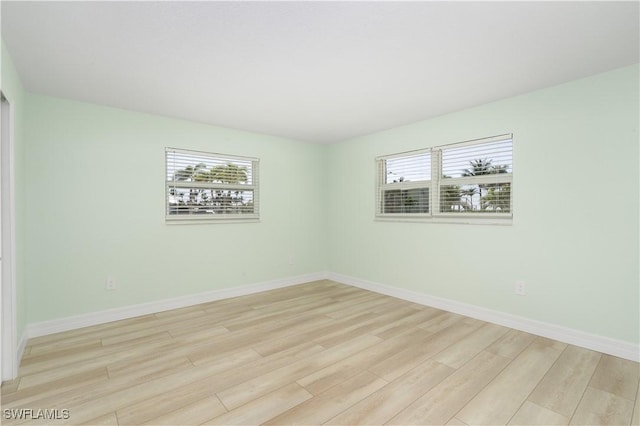 unfurnished room with light wood finished floors and baseboards