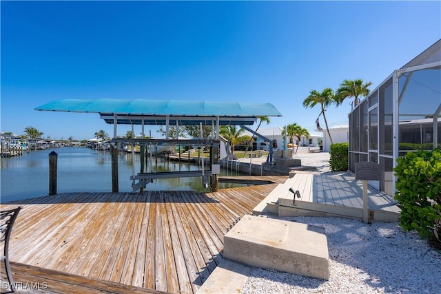 dock area featuring a water view, boat lift, and a lanai