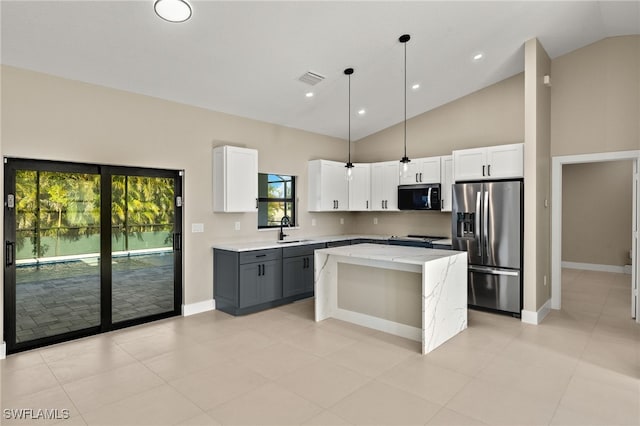 1008 NW 36th Pl, Cape Coral, FL 33993 - kitchen with pendant lighting, a kitchen island, light stone countertops, stainless steel fridge, and a sink