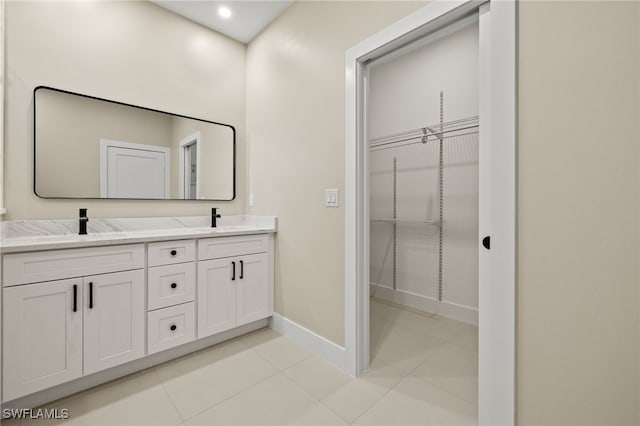 1008 NW 36th Pl, Cape Coral, FL 33993 - bathroom with double vanity, tile patterned flooring, a sink, baseboards, and a spacious closet