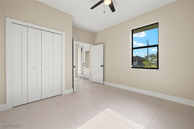 1008 NW 36th Pl, Cape Coral, FL 33993 - unfurnished bedroom featuring light tile patterned floors, baseboards, a ceiling fan, and a closet