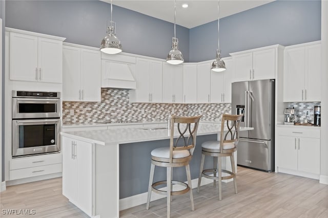 11498 Tiverton Trce, Fort Myers, FL 33913 - kitchen featuring appliances with stainless steel finishes, custom exhaust hood, tasteful backsplash, light countertops, and a center island with sink