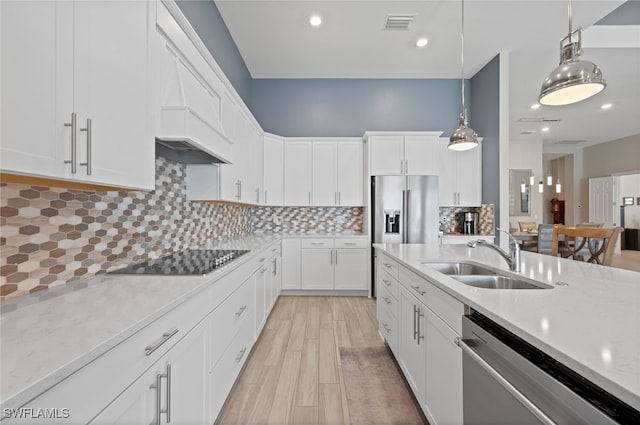 11498 Tiverton Trce, Fort Myers, FL 33913 - kitchen with appliances with stainless steel finishes, a sink, hanging light fixtures, white cabinetry, and light wood-style flooring