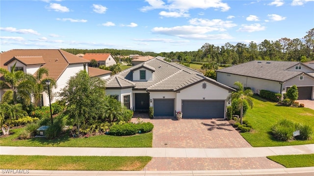 11498 Tiverton Trce, Fort Myers, FL 33913 - view of front of house featuring a garage, a tiled roof, decorative driveway, a front yard, and stucco siding