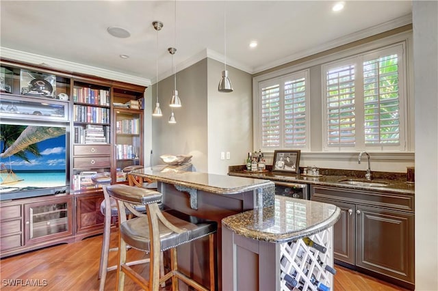 1947 Gordon River Ln, Naples, FL 34104 - bar featuring pendant lighting, ornamental molding, beverage cooler, a sink, and light wood-style flooring