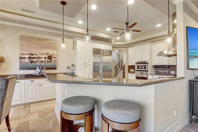 1947 Gordon River Ln, Naples, FL 34104 - kitchen with crown molding, appliances with stainless steel finishes, a ceiling fan, and white cabinetry