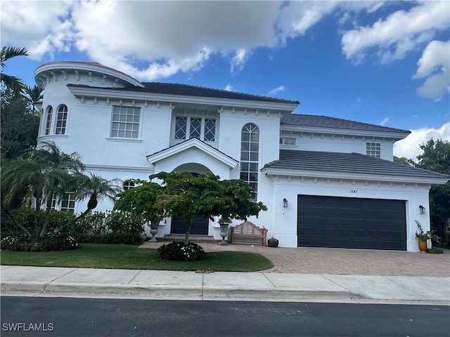 1947 Gordon River Ln, Naples, FL 34104 - view of front of house featuring a garage, decorative driveway, and stucco siding