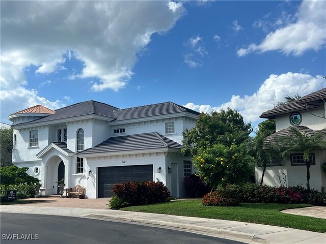 1947 Gordon River Ln, Naples, FL 34104 - mediterranean / spanish-style house featuring an attached garage, a front lawn, stucco siding, and driveway