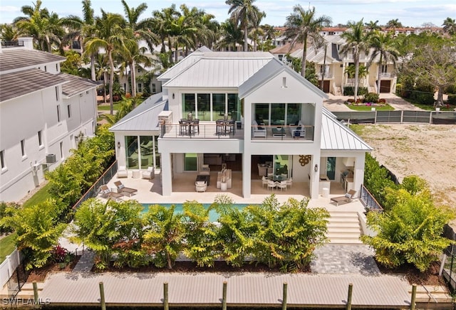 1380 Pelican Ave, Naples, FL 34102 - back of property featuring a balcony, a standing seam roof, a patio area, metal roof, and stucco siding
