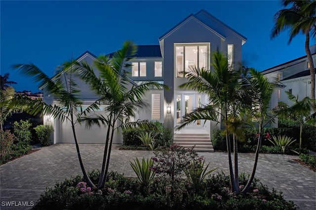 1380 Pelican Ave, Naples, FL 34102 - view of front of home featuring a garage, stucco siding, decorative driveway, and metal roof