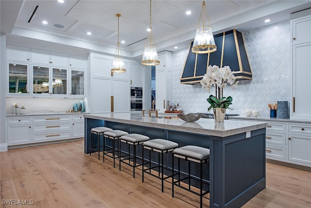 1380 Pelican Ave, Naples, FL 34102 - kitchen featuring a sink, a kitchen breakfast bar, a spacious island, light stone counters, and white cabinets
