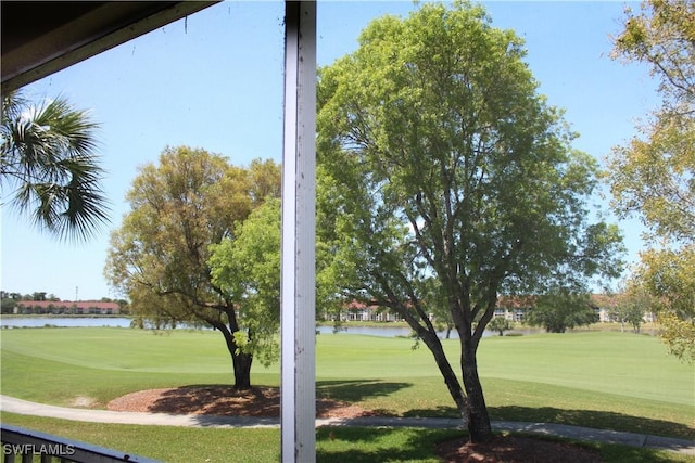 view of property's community with a lawn, a water view, and view of golf course