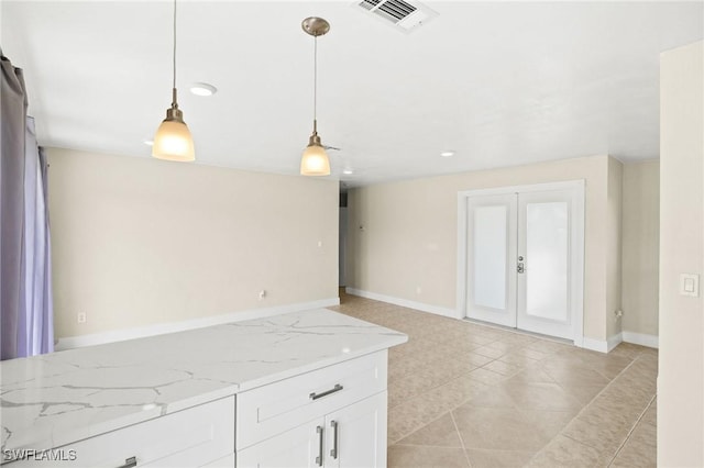 kitchen featuring white cabinets, light stone countertops, baseboards, visible vents, and pendant lighting