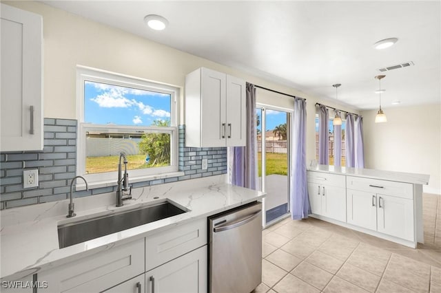 kitchen with a sink, decorative light fixtures, tasteful backsplash, stainless steel dishwasher, and visible vents