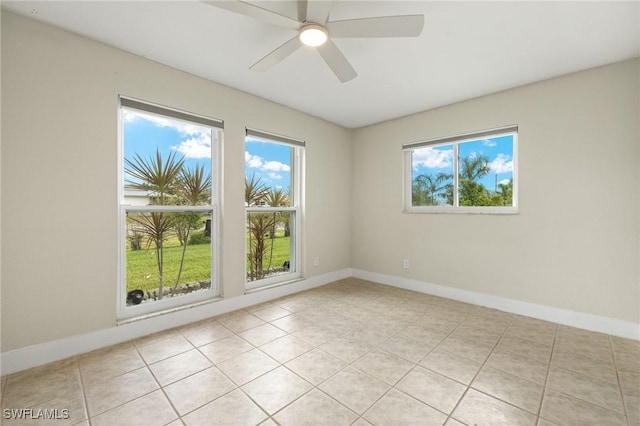 unfurnished room featuring baseboards, ceiling fan, and light tile patterned floors