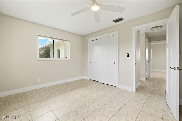 unfurnished bedroom with visible vents, baseboards, light tile patterned floors, and a closet