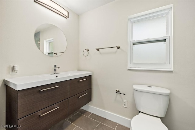 bathroom featuring toilet, baseboards, tile patterned flooring, and vanity