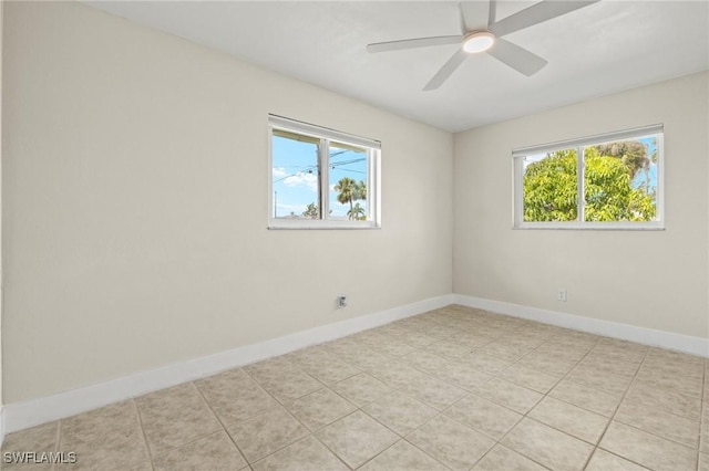 spare room with a ceiling fan, baseboards, and a healthy amount of sunlight