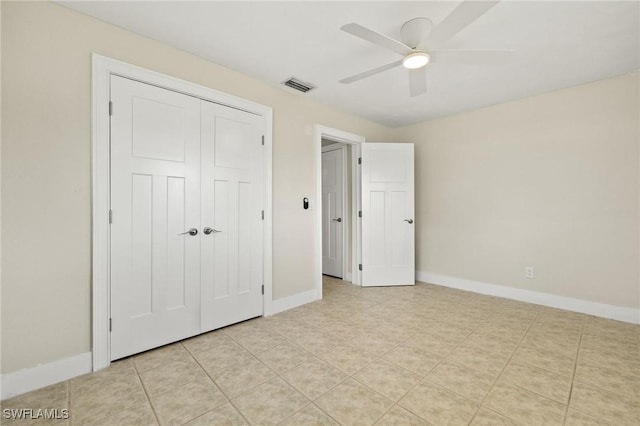 unfurnished bedroom with a ceiling fan, visible vents, light tile patterned floors, baseboards, and a closet