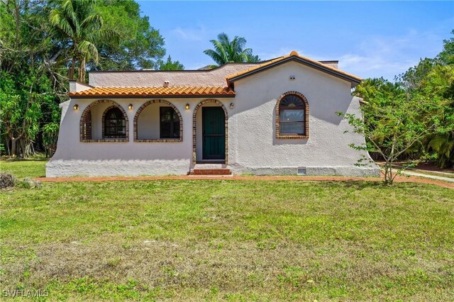 1725 Coronado Rd, Fort Myers, FL 33901 - mediterranean / spanish house featuring stucco siding, a porch, and a front lawn