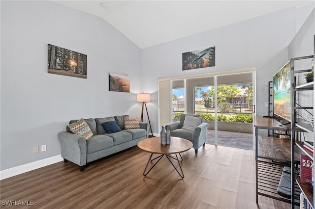 living area with baseboards, vaulted ceiling, and wood finished floors