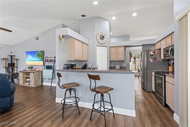 kitchen with visible vents, lofted ceiling, light brown cabinets, open floor plan, and appliances with stainless steel finishes