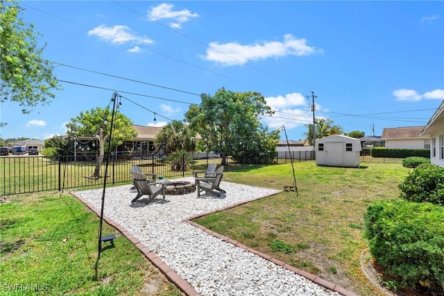 view of yard featuring a fire pit, a patio, a fenced backyard, a shed, and an outbuilding