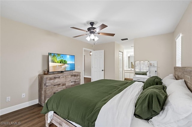 bedroom with baseboards, ceiling fan, dark wood finished floors, and connected bathroom